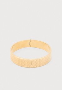 Bracelet jonc couleur or présentant un motif géométrique sur une surface plate, finition métallique lisse et fermeture à clip.