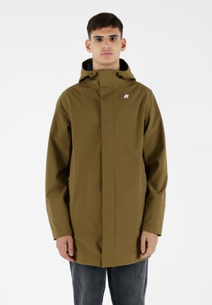 Giacca impermeabile verde oliva con colletto alto, due tasche laterali e un piccolo logo sul petto. Progettata con un taglio dritto.