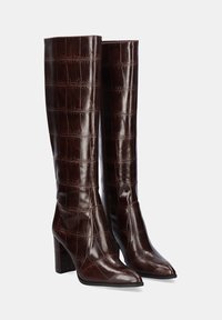 Botas de cuero marrón hasta la rodilla con textura de cocodrilo, puntera afilada y tacón cuadrado. Acabado liso con detalle de costura mínimo.