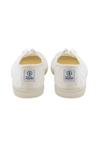 Bijele platnene cipele za klizanje s cvjetnim uzorkom, mekanim rubovima i gumenim potplatima. Imaju zelenu i crnu oznaku na peti.