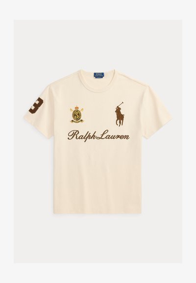 Krém színű Ralph Lauren póló barna póni játékos logóval, a jobb ujján a 3-as számmal és címerrel a bal mellrészen.