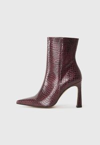 Stivaletto borgogna con punta affusolata, realizzato in pelle sintetica a texture coccodrillo. Presenta un tacco a stiletto e una fodera interna liscia.