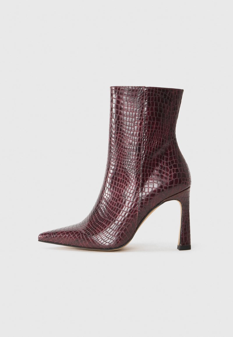 Stivaletto borgogna con punta affusolata, realizzato in pelle sintetica a texture coccodrillo. Presenta un tacco a stiletto e una fodera interna liscia.