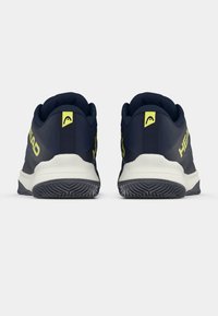 Jūras spēku sporta apavi ar gludu tekstilu augšdaļu, dzelteniem akcentiem un baltu viduspēdu, ar rakstainu gumijas ārējo zoli, kas nodrošina saķeri.