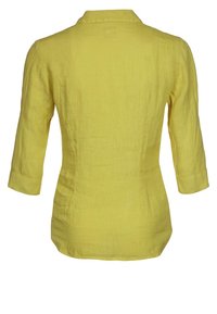 Camisa de lino amarilla con cuello, mangas tres cuartos y silueta ajustada. Tejido texturizado y ligero. Sin patrones visibles.