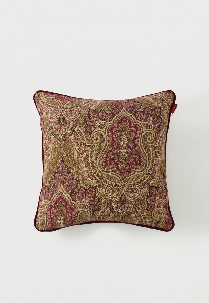 Coussin carré décoratif avec un motif cachemire vintage complexe en tons bordeaux, or et beige, bordé d'un passepoil bordeaux foncé.