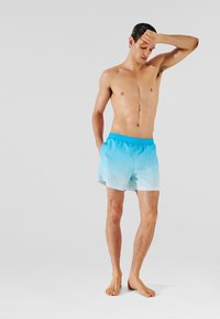 Plivačke kratke hlače u gradient plavoj boji, izrađene od laganog, glatkog materijala. Elastična waistband, bočne džepove i kroj iznad koljena.