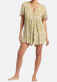 Grön blommig playsuit med korta flygiga ärmar, V-ringning, knappar framtill och lös passform. Har rosa och blå blommor på en strukturerad bakgrund.