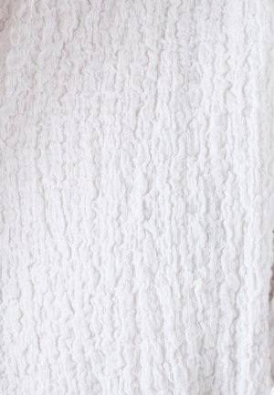 Tela blanca texturizada con un patrón ondulado, que presenta una superficie suave y arrugada y una apariencia ligera y aireada.
