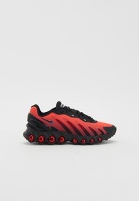 Chaussure de course Nike avec une tige en mesh dégradé rouge et noir, une semelle intermédiaire noire texturée, et des coussins de rembourrage rouges distinctifs.