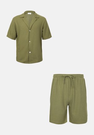 Camisa verde de manga corta con botones y cuello, combinada con pantalones cortos ajustables a juego, ambos hechos de tela texturizada.