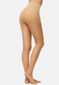Shorts beige sin costuras con una textura suave, cinturilla de altura media y un diseño ajustado que cubre la parte superior de los muslos.
