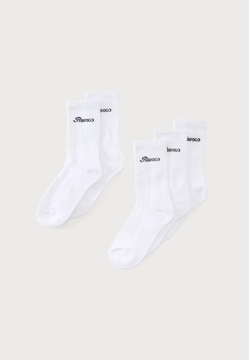Deux paires et un lot de trois chaussettes blanches montantes avec un logo noir « Bucos » sur les bord-côtes, présentées sur un fond clair.