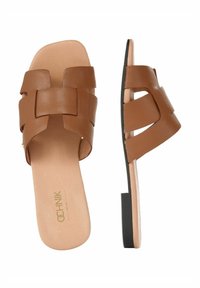 Brązowe skórzane klapki z plecionym wzorem paska, płaską czarną podeszwą z teksturowanym brzegiem i gładką, beżową wkładką.