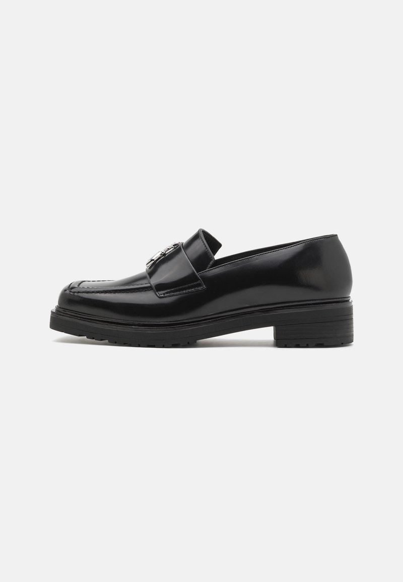 Zwarte lakleren loafers met een ronde neus, decoratieve band en zilveren hardware details aan de voorkant. Vierkante hak en gestructureerde zool.