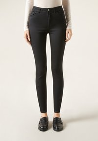 Jeans ajustados negros con cintura alta, que cuentan con bolsillos delanteros y cierre de botón. La tela es suave y elástica para mayor comodidad.
