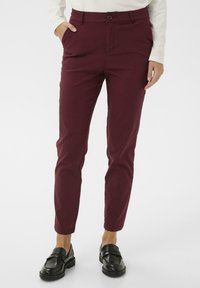 Burgundské strihové bavlnené nohavice so slim fit, prednými vreckami a zapínaním na jeden gombík. Skombinované s čiernymi poltopánkami.