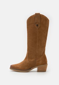 Bota de ante marrón hasta la rodilla con punta ligeramente afilada, tacón apilado, costuras decorativas y un acento triangular cerca de la parte superior.