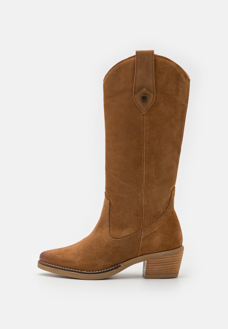 Bota de ante marrón hasta la rodilla con punta ligeramente afilada, tacón apilado, costuras decorativas y un acento triangular cerca de la parte superior.