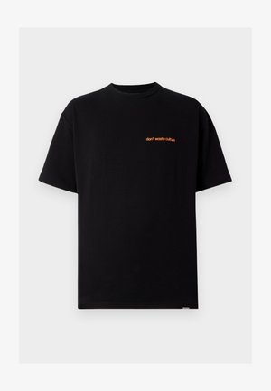 Sort bomulds-t-shirt med korte ærmer og rund hals. Har orange tekst "don't waste culture" på øverste venstre side.