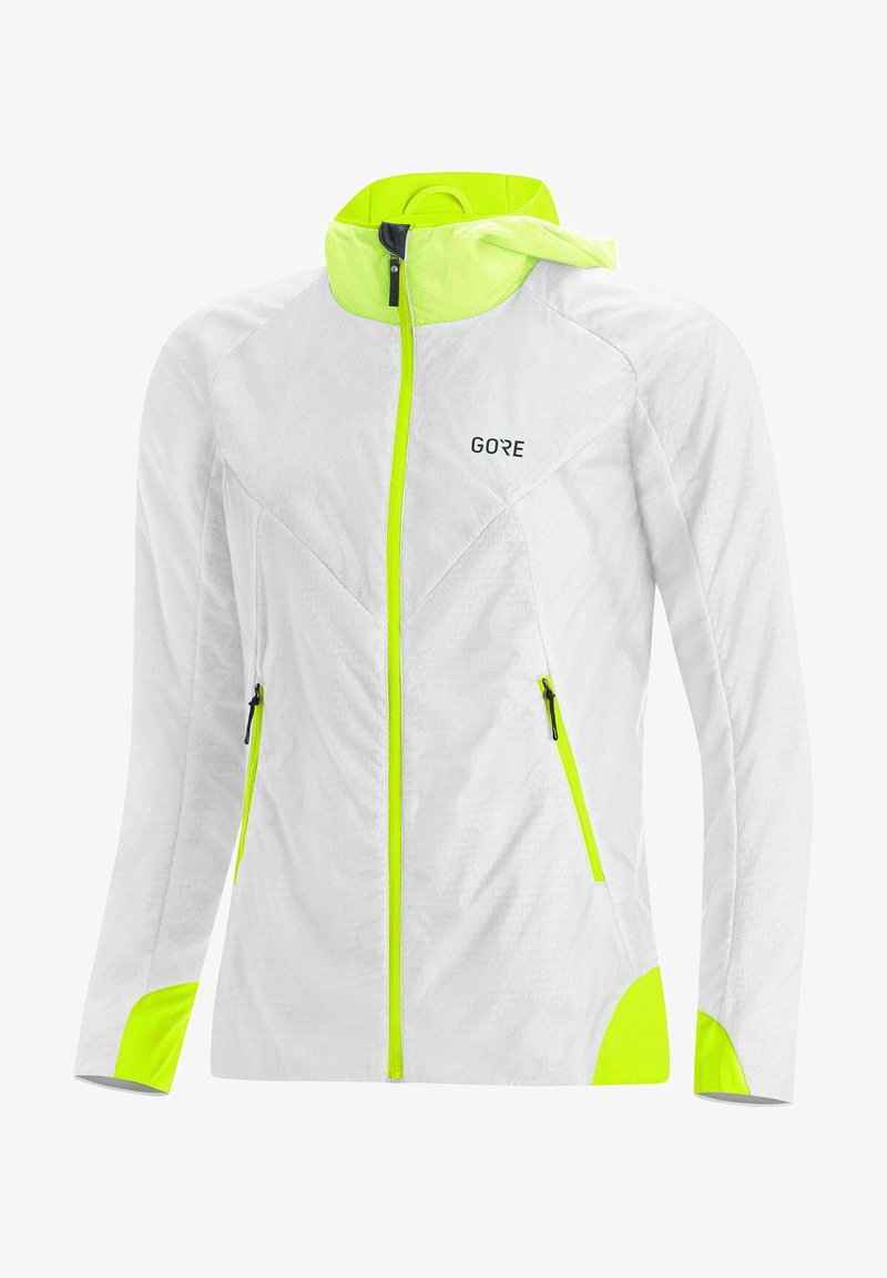 Chaqueta ligera blanca con acentos en amarillo neón, con cierre de cremallera, dos bolsillos laterales y capucha. Tejido texturizado para mayor transpirabilidad.