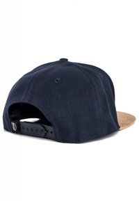 Marineblaues Kordmütze mit einem hellbraunen Frontschirm, verstellbarem Riemen an der Rückseite und kleinem Logodetail nahe dem Riemen.