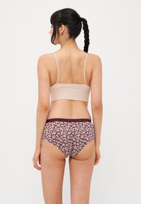 Bralet bej cu texture din tricot, cu bretele subțiri, asortat cu chiloți purpuriu cu imprimeu floral, cu talie înaltă, având un brâu solid și o textură moale a materialului.