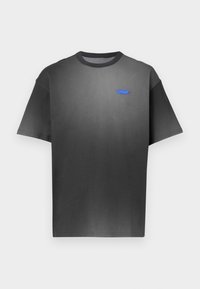 Γκρι κοντομάνικη μπλούζα με διακριτική διαβάθμιση χρώματος, στρογγυλή λαιμόκοψη και μικρό μπλε λογότυπο στο στήθος. Ομαλή υφή υφάσματος.