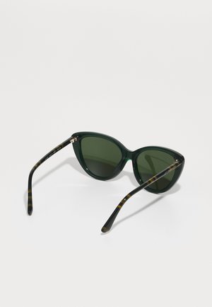 Lunettes de soleil en plastique vert en forme de yeux de chat avec des verres sombres. Accents rayés marron et noir sur les branches. Texture lisse, design minimaliste.