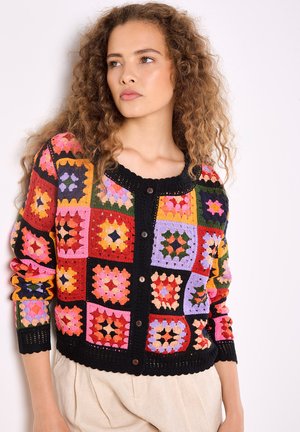 Cardigan all'uncinetto colorato con motivi a quadri in rosso, rosa, giallo, verde e viola, con rifiniture nere e chiusura a bottone.