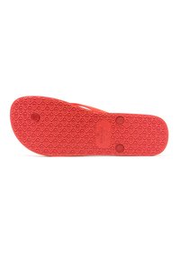 Suela de sandalia de goma roja con un patrón de agarre texturizado, que presenta dos indentaciones circulares y un estampado de logo en el centro.