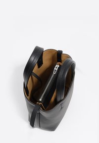 Czarna skórzana torba na ramię z dwoma uchwytami, otwartym wierzchem odsłaniającym beżowe wnętrze oraz centralną komorą zapinaną na suwak z srebrnym suwakiem.