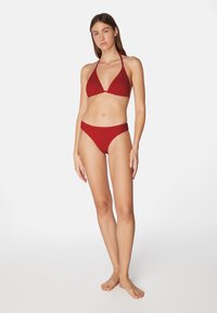 Roter Bikini bestehend aus einem strukturierten dreieckigen Oberteil mit verstellbaren Trägern und passenden hochgeschnittenen Unterteilen. Schlichtes Design in einfarbig.