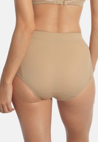 Mutande beige a vita alta realizzate in tessuto morbido, con un design senza cuciture e una cintura elastica per il massimo comfort.
