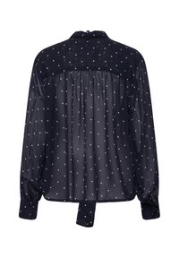 Blouse bleu marine à manches longues avec pois blancs, tissu transparent, dos froncé, poignets boutonnés et lien en tissu au cou.