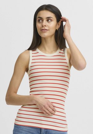 Cremefarvet tanktop med røde vandrette striber, ribbet tekstur og rund halsudskæring. Model iført blå jeans, hånd nær ansigtet.