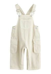 Beige cotton overalls with adjustable shoulder straps, two side pockets, and a front pocket. Smooth texture with reinforced stitching.