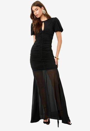 Black ruched dress with short puff sleeves and a keyhole neckline. Sheer skirt overlay and fitted bodice, featuring smooth texture and silhouette.