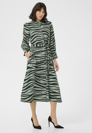 Knapp-up, långärmad klänning i grön med svarta zebra randar. Har en knytmidja, fickor och en avslappnad passform. Slät tygtextur.