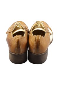 Helle Lederschuhe in Tan mit glatter Textur, abgerundeter Spitze und niedrigem braunem Absatz. Mit weißen Seitenakzenten und Schnürdesign.