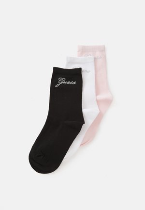 Trois paires de chaussettes de cheville en noir, blanc et rose. Chacune présente un petit logo brillant cousu près du haut. Finition en coton lisse.
