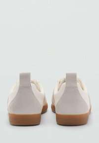 Sneaker beige con tomaia in pelle liscia e dettagli in suede taupe. Forma arrotondata, suole in gomma e suole esterne in tonalità contrastante color cammello.