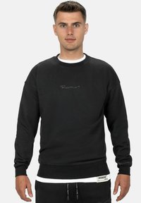 Felpa nera in cotone con collo rotondo e polsini a coste. Presenta un ricamo del logo discreto sul petto e un'etichetta all'orlo.