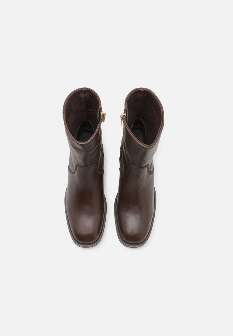 Braune Lederstiefeletten mit glatter Oberfläche, abgerundeter Spitze und dekorativen Nähten. Mit einem Reißverschluss in Goldoptik oben am Schaft.