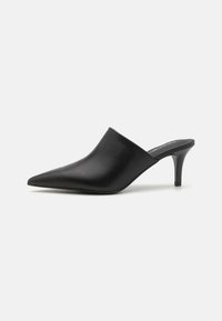 Mules noirs en cuir avec un bout pointu, une texture lisse et un talon haut slim, présentant un design à enfiler et sans quincaillerie visible.