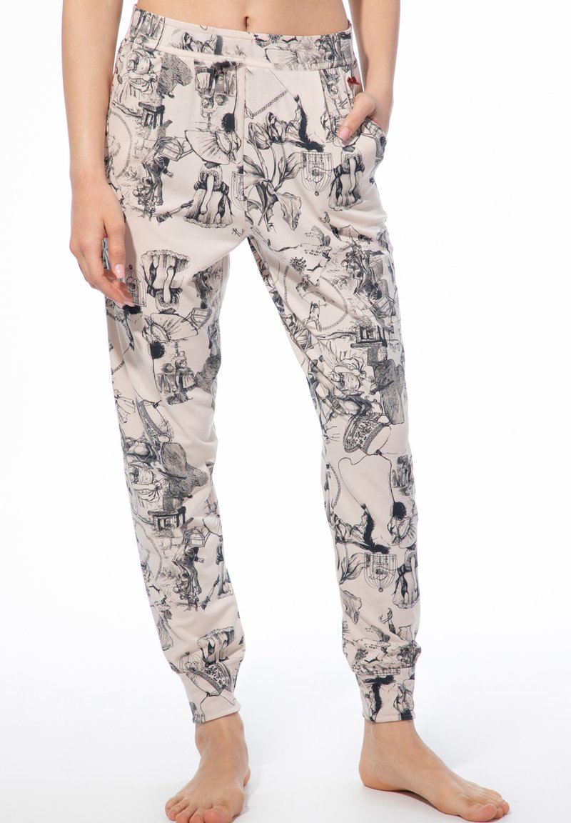 Lässige Jogginghosen aus weichem Stoff, mit beigem Hintergrund und detaillierten schwarzen Illustrationen, seitlichen Taschen und elastischen Bündchen an den Knöcheln.