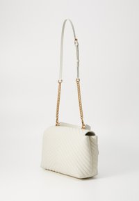 Baltas izšūts rokassomas ar čevronu rakstu, kas aprīkota ar ķēdes un ādas siksnu, kā arī zelta toņu apdares akcentiem. Tekstūru ādas apdare.