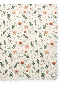 Floral-patterned cotton throw with cream background, featuring orange and green flowers, leaves, and fringe edges. Brand label on corner.