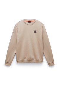 Sudadera beige con cuello redondo, mangas largas y puños de canalé. Presenta un parche redondo en el pecho y un detalle naranja en el cuello.
