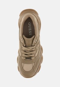 Beige Guess lenkkarit, joissa on verkko- ja nahkapaneelit, paksu kumipohja, nauhat ja näkyvä brändilogo kielekkeellä ja nauhatunnuksessa.
